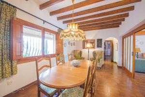 a dining room with a wooden table and chairs at Villa Mas Blanc - PlusHolidays in Benissa