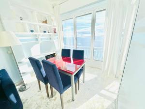 een eetkamer met een rode tafel en blauwe stoelen bij Suite Casa del Sole 16 - Fronte Mare in Sanremo