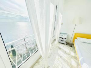 een slaapkamer met een groot raam met uitzicht op de oceaan bij Suite Casa del Sole 16 - Fronte Mare in Sanremo