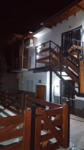 un edificio con una escalera de madera delante de él en Departamento Genaro en Mina Clavero