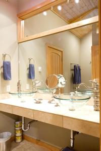 ein Badezimmer mit 3 Waschbecken und einem großen Spiegel in der Unterkunft Waterfront Chalet in Maple Falls