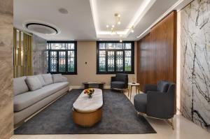 Gleam Collection Hotel في إسطنبول: غرفة معيشة مع أريكة وطاولة وكراسي