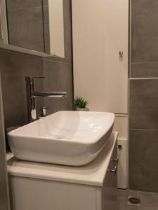 lavabo blanco sentado en una encimera en el baño en Come & Stay apt, en Ierápetra