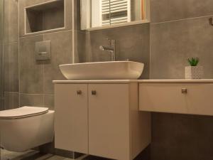 a bathroom with a sink and a toilet at Come & Stay apt in Ierápetra