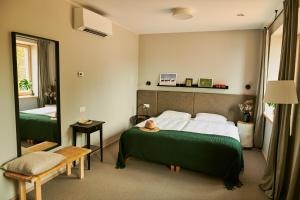 a hotel room with a bed and a mirror at Barono Vila in Butėnai