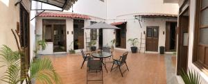un patio con mesa, sillas y sombrilla en Villa Coco63, en Campeche