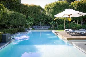 a swimming pool with an umbrella and two lounge chairs at 14 on Klein Constantia in Cape Town