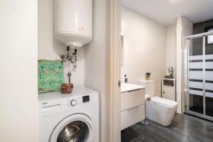 eine weiße Waschküche mit einer Waschmaschine und einem WC in der Unterkunft Apartamento Casa da barbeira in Cangas