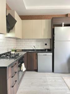 a kitchen with a white refrigerator and a sink at Merkezi konumda yeni dekore edilmiş şık daire in Mersin