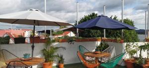 dwa stoły i parasole na patio z roślinami w obiekcie Hostal Tah Itza w mieście Flores