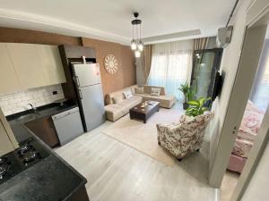 a kitchen and a living room with a refrigerator at Merkezi konumda yeni dekore edilmiş şık daire in Mersin