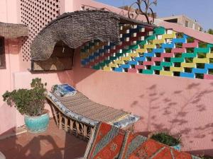 a bench on the side of a building with a colorful wall at Ra Guest house in Cairo