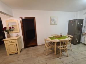 Una cocina con mesa y sillas y un refrigerador. en Clasic Apartment Nufarul, en Oradea 16 fotos más