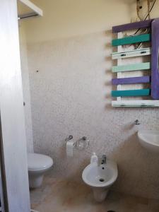 y baño con aseo y lavamanos. en Finestre Sul Mare Salento - Case Vacanze, en Punta Prosciutto