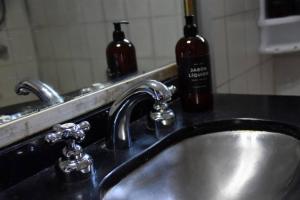 lavabo con 2 botellas de vino en el baño en Departamento en el tradicional Barrio de Almagro en Buenos Aires