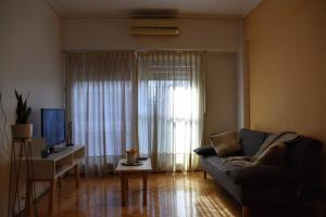 sala de estar con sofá y ventana en Departamento en el tradicional Barrio de Almagro en Buenos Aires