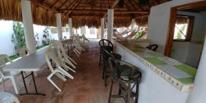 een restaurant met witte tafels en stoelen in een kamer bij Mi Pequeño Cielo 