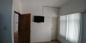 een kamer met een flatscreen-tv aan de muur bij Mi Pequeño Cielo 