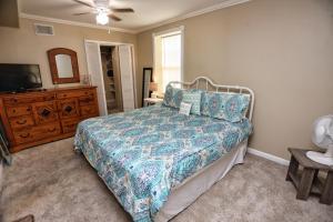 a bedroom with a bed and a dresser and a television at Quick & Intimate Beach Getaway in Galveston