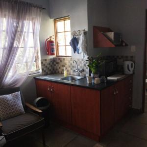 a kitchen with a sink and a counter top at Aan die Voet van die Magalies in Pretoria
