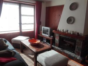 a living room with a fireplace and a tv at Apartamento Duplex Esterri ideal para familias in Esterri d'Àneu