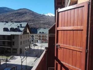 una puerta roja abierta con vistas a la ciudad en Apartamento Duplex Esterri ideal para familias en Esterri d'Àneu