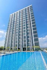 um grande edifício com uma grande piscina em frente em Homestay Ibu Shah Alam with pool near icity uitm em Shah Alam