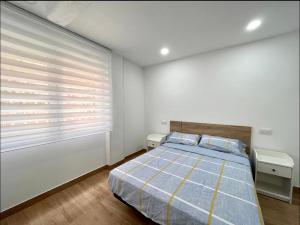 a bedroom with a bed and a window with blinds at Maximilian Dreams in Madrid