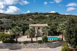 an image of a villa with palm trees and a swimming pool at Teachers Cottage in Agia Triada