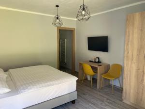a bedroom with a bed and a desk and a television at Hotel pod Kapličkou in Malá Morávka