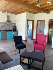 uma sala de estar com duas cadeiras e um sofá vermelho em Apartamentos y Casa La Paredana, agroturismo em Fontoria