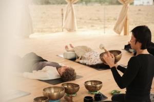 a group of people in a room with bowls on the floor at Heenat Salma Farm in Mu‘askar al Buşayyir