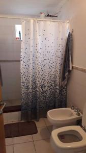 a bathroom with a toilet and a shower curtain at El Teyu de Garupa in Garupá