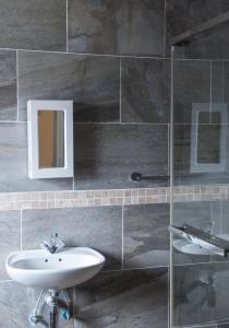 La salle de bains est pourvue d'un lavabo et d'un miroir. dans l'établissement Haithoms Guesthouse, à Gaborone