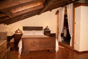 una camera con letto in una stanza con soffitti in legno di La Breval ad Alles