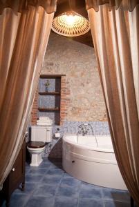 a bathroom with a bath tub and a toilet at La Breval in Alles