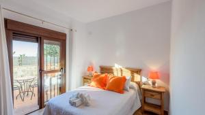 a bedroom with a bed with orange pillows and a balcony at Apto El Descanso I Conil de la Frontera by Ruralidays in Conil de la Frontera +22 photos