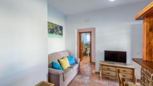 a living room with a couch and a tv at Apto El Descanso I Conil de la Frontera by Ruralidays in Conil de la Frontera