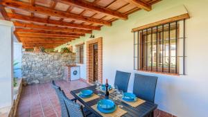 a dining room with a table and chairs and a stone wall at Apto El Descanso I Conil de la Frontera by Ruralidays in Conil de la Frontera