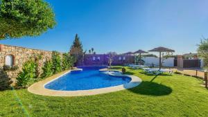 a pool in a yard with chairs and an umbrella at Apto El Descanso I Conil de la Frontera by Ruralidays in Conil de la Frontera