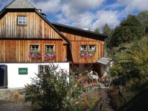 a wooden house with flowers on the windows at Landhaus Gschmeidler in Selzthal