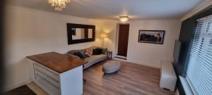 a living room with a couch and a table at Laighdykes Guest Cottage in Saltcoats