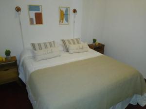 Un dormitorio con una cama blanca con almohadas. en Departamento 20 de Febrero Premium en Salta