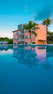 una gran piscina con un edificio y palmeras en MAKARY BEACH HOTEL en Tolú