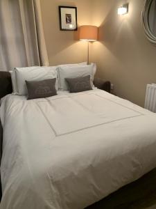 un grande letto bianco con due cuscini sopra di Slane Stay, Belfast a Belfast