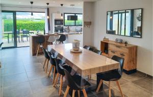 Una cocina y un comedor con mesa y sillas de madera. en 3 Bedroom Awesome Home In Plouguerneau, en Plouguerneau