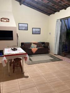 Barrinha dos Ventos في ساو لورينسو دو سول: غرفة معيشة مع أريكة وطاولة