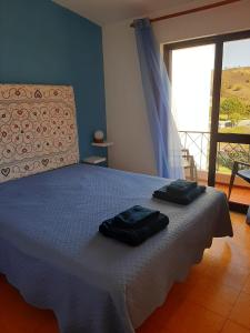 a bedroom with a bed with two towels on it at Casa dos Pais in Odeceixe