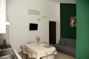 cocina con mesa con sillas y sofá en Appartamenti Casa Sofia, en Castello di Cisterna