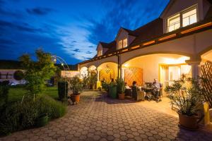 a house with people sitting on a patio at night at Appartementhaus Martina in Mörbisch am See